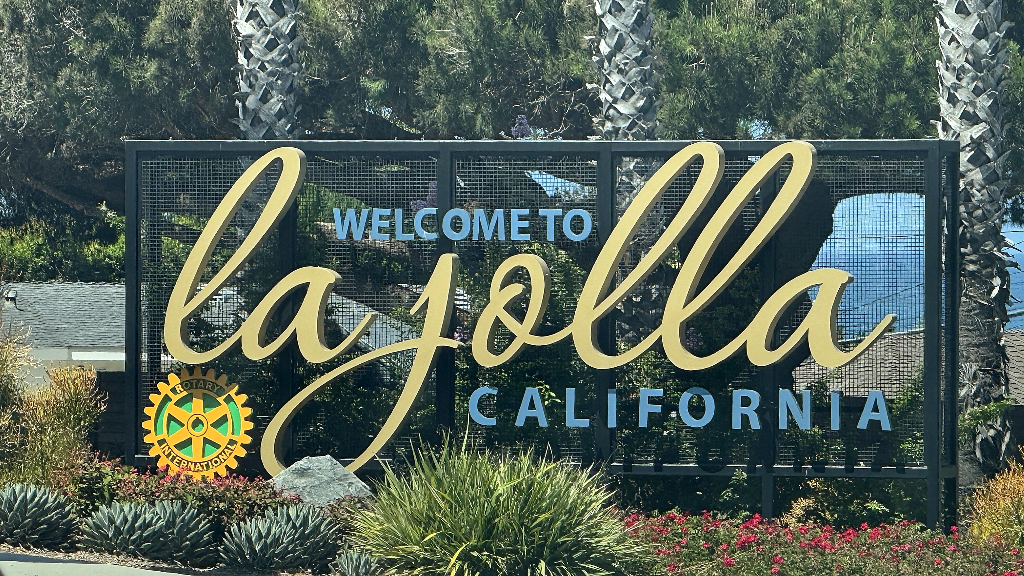 Welcome to La Jolla California landmark sign with gold lettering and palm trees